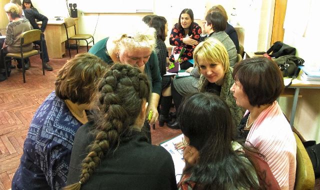 консультує учасників тренінгу з приводу виконнання завдання у "Колі ідей" 